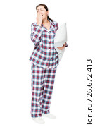 Yawning sleepy woman in warm pajamas holds ready pillow on white background isolated. Стоковое фото, фотограф Константин Лабунский / Фотобанк Лори