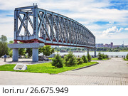 Сохранённая, как музейный экспонат, пролётная конструкция первого железнодорожного моста через реку Обь ( Построен в 1893—1897 годах по проекту Н. А. Белелюбского ) на  Михайловской набережной в парке  ,, Городское начало ,,. Новосибирск, Сибирь, Россия (2017 год). Редакционное фото, фотограф Евгений Мухортов / Фотобанк Лори