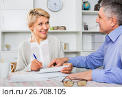 Mature married couple discuss contract and sign important documents. Стоковое фото, фотограф Яков Филимонов / Фотобанк Лори