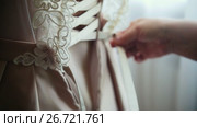 Bridesmaid buttoning dress at bride's home, close up. Стоковое видео, видеограф Константин Шишкин / Фотобанк Лори