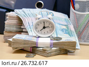 Время платить налоги. Часы - будильник, ручки, карандаши и много российских денег на фоне деловых папок. Стоковое фото, фотограф Наталья Осипова / Фотобанк Лори
