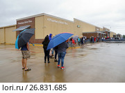 HOUSTON, USA - AUGUST 29, 2017: Consequences of the  Hurricane Harvey. Desperate Texans line up in the rain as grocery stores Walmart start to reopen. Редакционное фото, фотограф Ирина Кожемякина / Фотобанк Лори