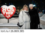 Две женщины средних лет стоят на фоне Стелы "Я люблю Тулу" вечером (2017 год). Редакционное фото, фотограф Игорь Низов / Фотобанк Лори