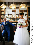 Newlyweds at the bar scene, the bride laughs cheerfully, the groom sits on a bar stool, good lighting. Стоковое фото, фотограф Евгений Майнагашев / Фотобанк Лори