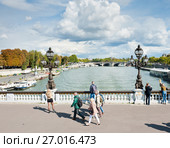 Прохожие на мосту Александра III (фр. Pont Alexandre III). Солнечный день ранней осенью. Париж. Франция (2017 год). Редакционное фото, фотограф E. O. / Фотобанк Лори