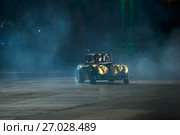 Гоночный автомобиль, дрифтующий в лучах света на 10 фестивале экстремальных видов спорта Прорыв в  спортивном комплексе Олимпийский. Стоковое фото, фотограф Pukhov K / Фотобанк Лори