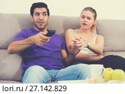 Woman trying to take away TV remote from boyfriend. Стоковое фото, фотограф Яков Филимонов / Фотобанк Лори