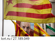 Неофициальный флаг каталонских земель (сепаратизма) развевается на фоне портрета Ленина во время прохождения делегации Испании в марше КПРФ, посвященном 100-й годовщине Октябрьской социалистической революции, на Тверской улице в центре города Москвы, Россия (2017 год). Редакционное фото, фотограф Николай Винокуров / Фотобанк Лори
