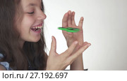 Beautiful cheerful teen girl playing with green fidget spinner on white background stock footage video. Стоковое видео, видеограф Юлия Машкова / Фотобанк Лори