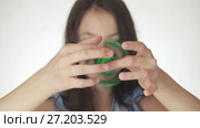 Beautiful cheerful teen girl playing with green fidget spinner on white background stock footage video. Стоковое видео, видеограф Юлия Машкова / Фотобанк Лори