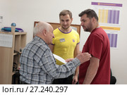 Пожилой мужчина задаёт вопрос врачу и тренеру центра доктора Бубновского, город Балашиха (2017 год). Редакционное фото, фотограф Дмитрий Неумоин / Фотобанк Лори