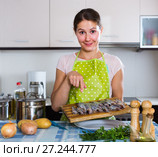 housewife trying new recipe of sprattus in kitchen. Стоковое фото, фотограф Яков Филимонов / Фотобанк Лори