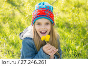 Семилетняя девочка весной радуется распустившимся одуванчикам. Стоковое фото, фотограф Иванов Алексей / Фотобанк Лори