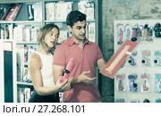 woman and man bayers choosing long rubber phallus in the sex shop. Стоковое фото, фотограф Яков Филимонов / Фотобанк Лори