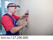 Hammer a nail in wall. Worker with hammer. Стоковое фото, фотограф Наталья Давыдова / Фотобанк Лори