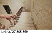 A staircase with a dark wooden railings in an abandoned architectural building. The legacy of the past. Shooting in motion with electronic stabilization. Стоковое видео, видеограф Mikhail Davidovich / Фотобанк Лори