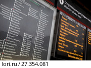 Информационное табло с расписанием отправления ближайших электричек и план остановок пригородных поездов Москвы и Московской области на Белорусском вокзале в Москве, Россия (2018 год). Редакционное фото, фотограф Николай Винокуров / Фотобанк Лори