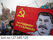 Мужчина держит портрет флаг с изображением Иосифа Сталина во время митинга-концерта "Россия в моем сердце" на Васильевском спуске города Москвы, Россия, 3 февраля 2018. Редакционное фото, фотограф Николай Винокуров / Фотобанк Лори