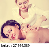 Young masseuse makes relaxing massage shoulder zone to adult woman. Стоковое фото, фотограф Яков Филимонов / Фотобанк Лори