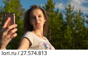 Pretty woman taking a selfie in summer park. Стоковое видео, видеограф Roman Larchikov / Фотобанк Лори