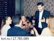 Young man pronouncing toast in cozy restaurant. Стоковое фото, фотограф Яков Филимонов / Фотобанк Лори