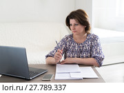 Woman working with documents looking at laptop. Стоковое фото, фотограф Володина Ольга / Фотобанк Лори