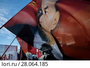 Участники шествия КПРФ, посвященного 100-летию Красной армии, размахивают флагом с портретом вождя Владимира Ильича Ленина на Страстном бульваре города Москвы, Россия (2018 год). Редакционное фото, фотограф Николай Винокуров / Фотобанк Лори
