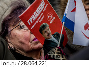 Женщина держит листовку в поддержку кандидата в президенты от партии КПРФ Павла Грудинина на митинге КПРФ на площади Революции в центре города Москвы, Россия, 23 февраля 2018. Редакционное фото, фотограф Николай Винокуров / Фотобанк Лори