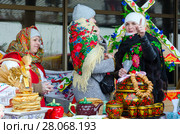 Масленичные гулянья. Три женщины за столом с блинами, сушками и расписной посудой (2018 год). Редакционное фото, фотограф Ольга Коцюба / Фотобанк Лори