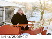Счастливая пара. Красивая женщина среднего возраста сидит на тележке на фоне заката (2018 год). Редакционное фото, фотограф Игорь Низов / Фотобанк Лори