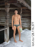 Naked man stands on ice near font with ice water in Russian Orthodox Monastery at winter day. Стоковое фото, фотограф Losevsky Pavel / Фотобанк Лори