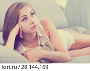 Disappointed girl lying on couch with cushion. Стоковое фото, фотограф Яков Филимонов / Фотобанк Лори