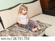 Девочка сидит на диване и смотрит телевизор. Стоковое фото, фотограф Кекяляйнен Андрей / Фотобанк Лори