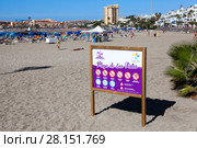 Информационный щит с правилами поведения на пляже Playa de Las Vistas в городе Los Cristianos. Атлантический океан, остров Тенерифе, Канары, Испания (2016 год). Редакционное фото, фотограф Кекяляйнен Андрей / Фотобанк Лори