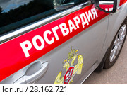 Inscription "Rosgvardia" and emblem of the troops of the National Guard of the Russian Federation on the board of car. Стоковое фото, фотограф FotograFF / Фотобанк Лори
