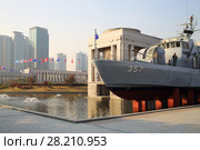 SEOUL - NOV 4, 2015: Military ship with cannonry in reservoir and highrise apartment buildings in military museum. In military museum was ceremony to mark 60th anniversary of armistice in Korea. Редакционное фото, фотограф Losevsky Pavel / Фотобанк Лори