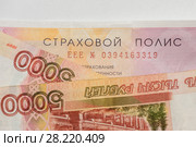Страхование автомобиля. Бланк страхового полиса страхования гражданской ответственности ОСАГО и деньги (2018 год). Редакционное фото, фотограф Игорь Низов / Фотобанк Лори