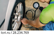 Auto mechanic checking tire pressure. Стоковое видео, видеограф Илья Шаматура / Фотобанк Лори