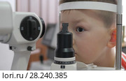 Child in an ophthalmic clinic. Little boy looking at a tonometer in the eye exam. Стоковое видео, видеограф Константин Мерцалов / Фотобанк Лори