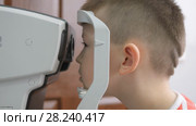 Child in an ophthalmic clinic. Little boy looking at a tonometer in the eye exam. Стоковое видео, видеограф Константин Мерцалов / Фотобанк Лори
