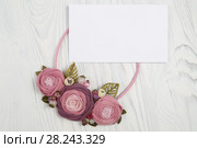 Handmade necklace with pink colored flowers lying on a white wooden background and letter with congratulation. Стоковое фото, фотограф Олег Белов / Фотобанк Лори