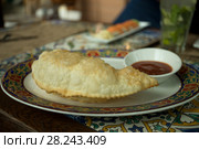 Чебурек с мясом на тарелке в ресторане. Стоковое фото, фотограф Литвяк Игорь / Фотобанк Лори