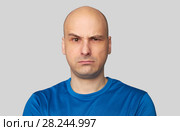 Uncertain bald man curves lips and raised eyebrow. Стоковое фото, фотограф Александр Лычагин / Фотобанк Лори
