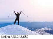 Climber exults reaching the top of the mountain peak. Стоковое фото, фотограф Евгений Харитонов / Фотобанк Лори