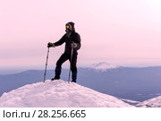 Mountaineer in a windproof mask and glasses reached the snow top of the mountain. Стоковое фото, фотограф Евгений Харитонов / Фотобанк Лори