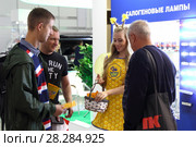 Молодая девушка стендистка (промоутер) на выставке общается с посетителем (2017 год). Редакционное фото, фотограф Илья Илмарин / Фотобанк Лори