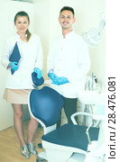 Stomatologist in uniform with his assistent are meeting next client behind the chair. Стоковое фото, фотограф Яков Филимонов / Фотобанк Лори