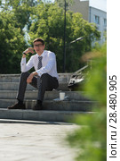 Well dressed business man smoking sitting on a street sidewalk. Стоковое фото, фотограф Kirill Kedrinskiy / Ingram Publishing / Фотобанк Лори