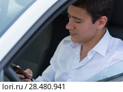 The young man behind the wheel driving car and calling phone. Стоковое фото, фотограф Kirill Kedrinskiy / Ingram Publishing / Фотобанк Лори