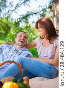 Adult couple picnicking in the summer park under the tree. Стоковое фото, фотограф Kirill Kedrinskiy / Ingram Publishing / Фотобанк Лори
